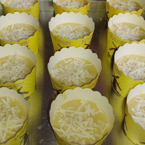 Siapkan cup muffin masukkan adonan kemudian taburi keju parut.