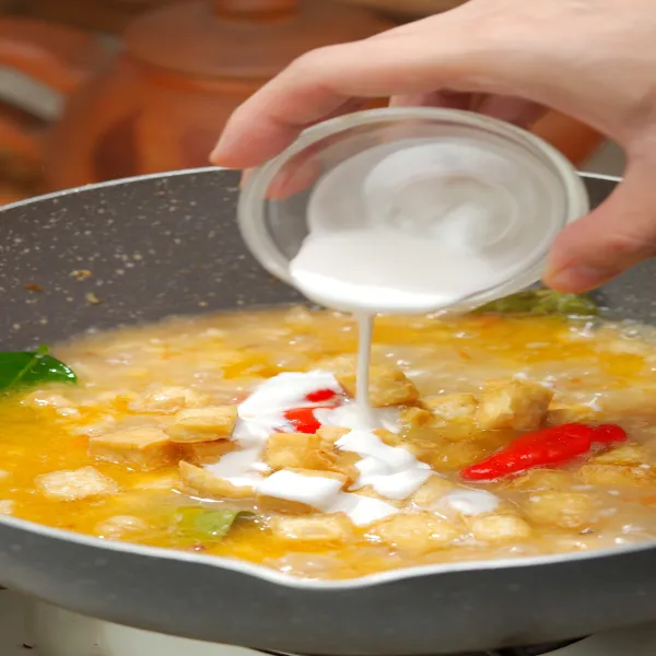 Masukkan tahu, santan dan cabe rawit. Masak sampai kuah sedikit menyusut dan mengental.