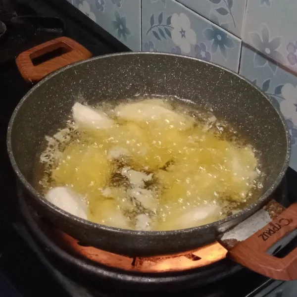 Celupkan pisang kepok ke dalam adonan tepung kemudian goreng sampai kuning kecoklatan