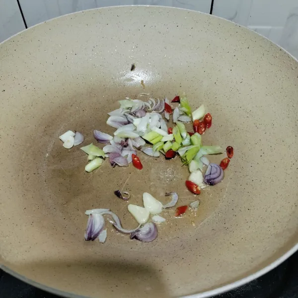 Tumis bawang merah, bawang putih, cabe merah, dan daun bawang hingga harum