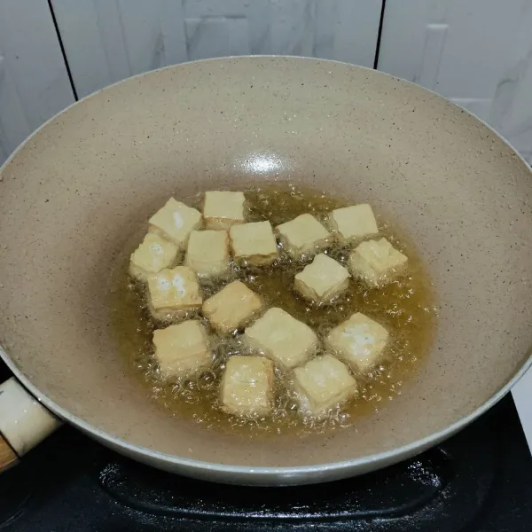 Potong tahu sesuai selera, lalu goreng hingga berkulit