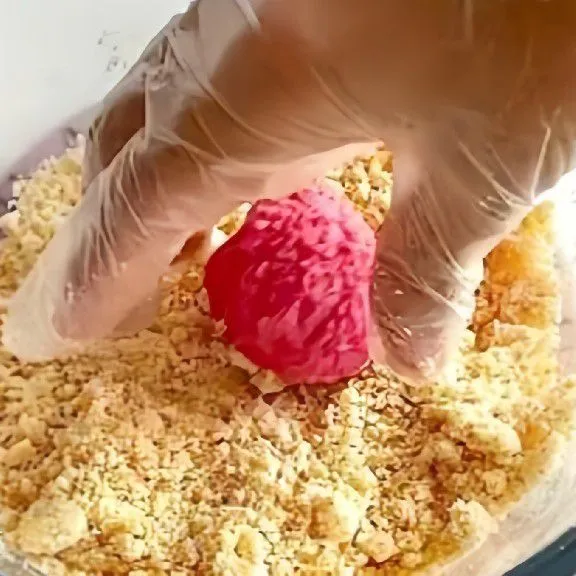 Gulirkan adonan di atas biskuit yang sudah di haluskan. Letakkan biskuit bola-bola di atas loyang yang dilapisi kertas. Panggang di oven dengan suhu 180°C selama 15-20 menit.