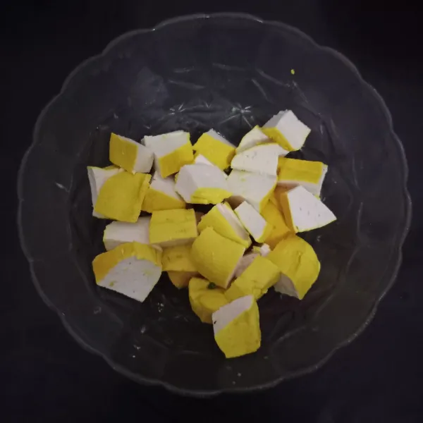 Potong dadu tahu, campurkan dengan bawang putih halus
