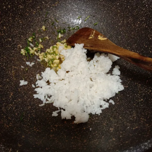Tambahkan nasi putih, lalu aduk rata.
