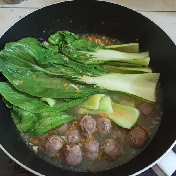 Setelah mendidih, masukkan bakso dan sawi pakcoy.