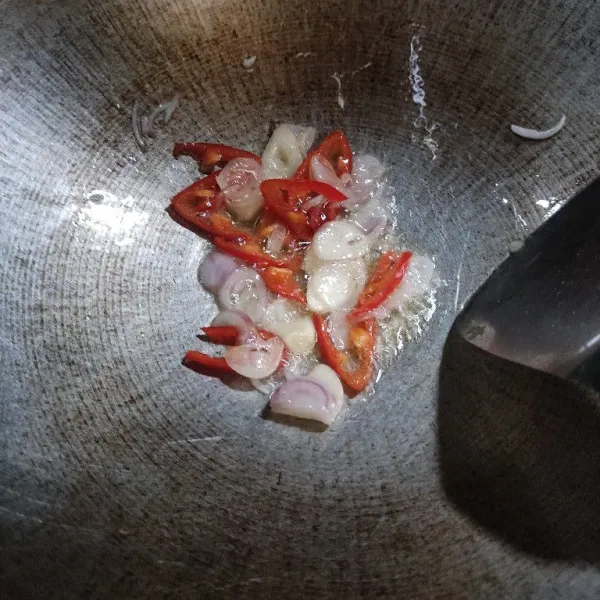Panaskan minyak, tumis duo bawang dan cabai merah hingga layu dan wangi.