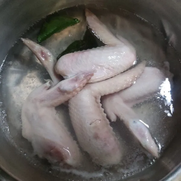 Rebus sayap ayam bersama daun jeruk hingga setengah matang, angkat dan tiriskan.