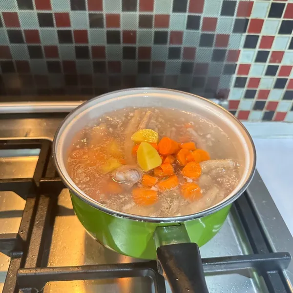 Masukkan irisan kentang dan wortel, biarkan empuk.