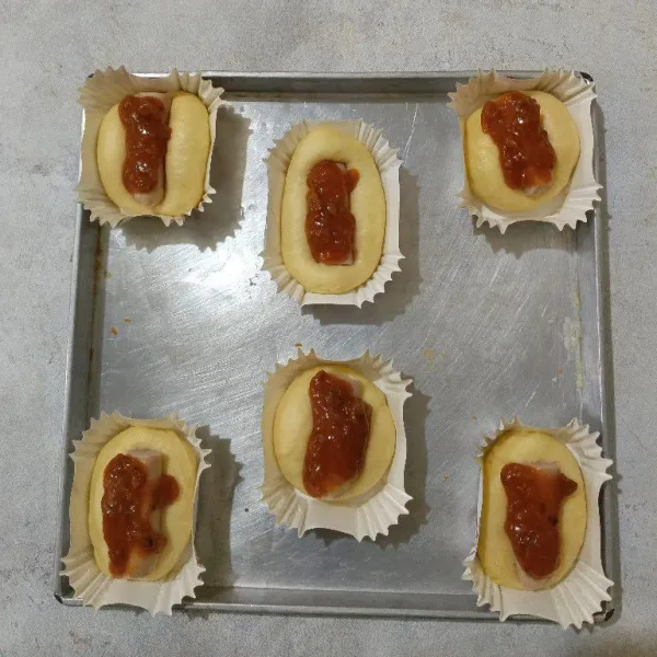 Ambil satu adonan, bentuk memanjang letakkan dalam cup, beri sosis, tambahkan saus bolognese diatas sosis.