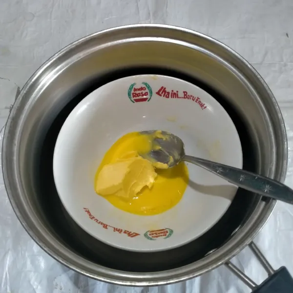 Didihkan air.Angkat panci,taruh mangkuk yang telah diisi margarin,aduk-aduk hingga margarin mencair