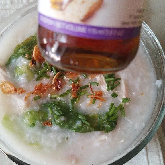 Angkat bubur dan pindahkan ke mangkuk saji. Tambahkan daun bawang, bawang goreng, dan minyak wijen.