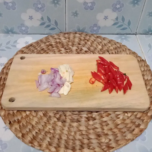 Iris-iris bawang merah, bawang putih, dan cabe keriting merah.