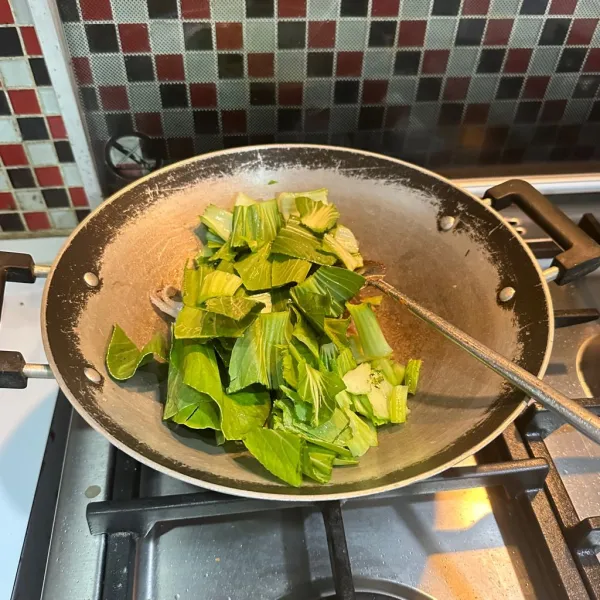 Masukkan irisan pokcoy, tambahkan air dan masak hingga layu.