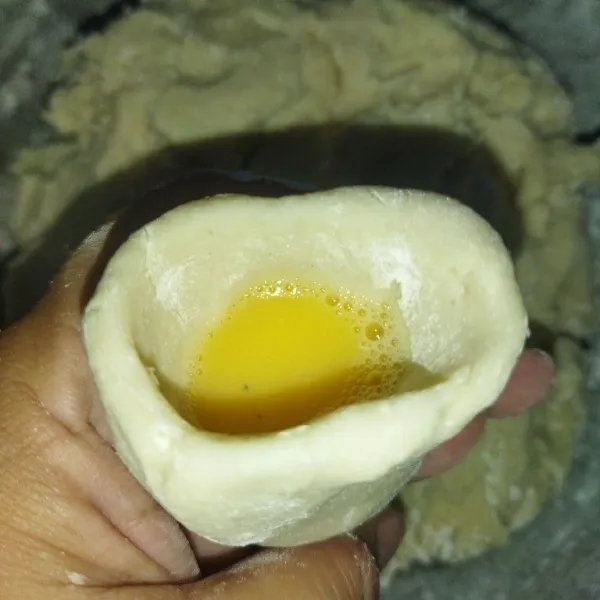 Taburi tangan dengan tepung tapioka, ambil adonan secukupnya, bentuk adonan kapal selam yang diisi dengan telur.