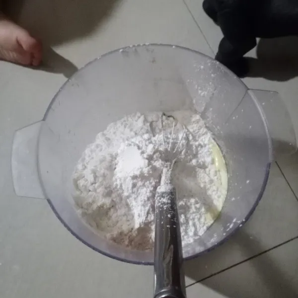Tambahkan terigu, tapioka, baking powder, dan baking soda sambil diayak, aduk rata.