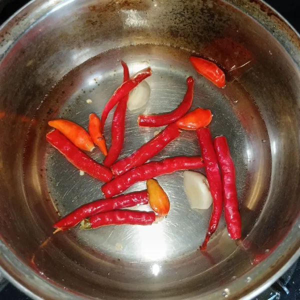 Membuat sambal, rebus cabai keriting, cabai rawit dan bawang putih sampai layu.