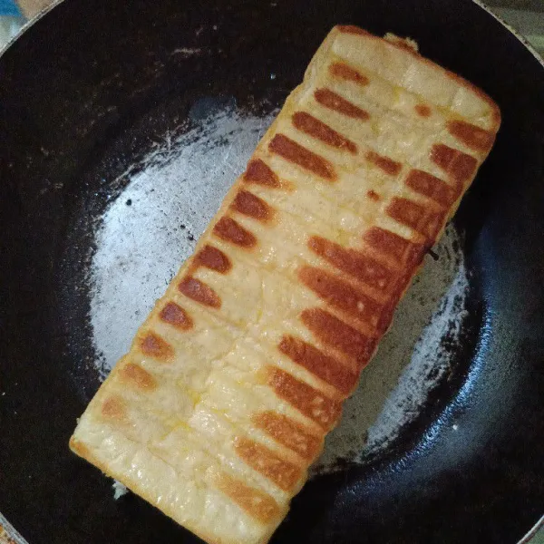 Panggang roti di atas teflon yang sudah dioles margarin. Gunakan api kecil. Bolak balik roti sampai matang.