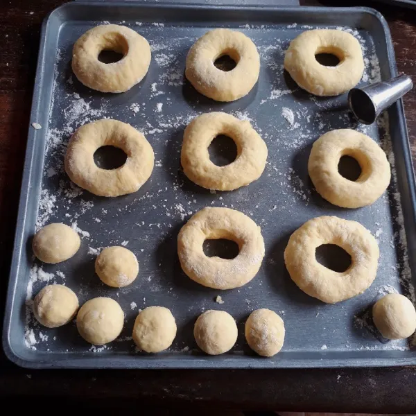 Kempiskan adonan, timbang seberat 35 gr, bulatkan, lakukan sampai adonan habis. Kemudian kempiskan adonan dan bentuk bulat pipih, lubangi bagian tengahnya. Diamkan selama 20 menit hingga mengembang.