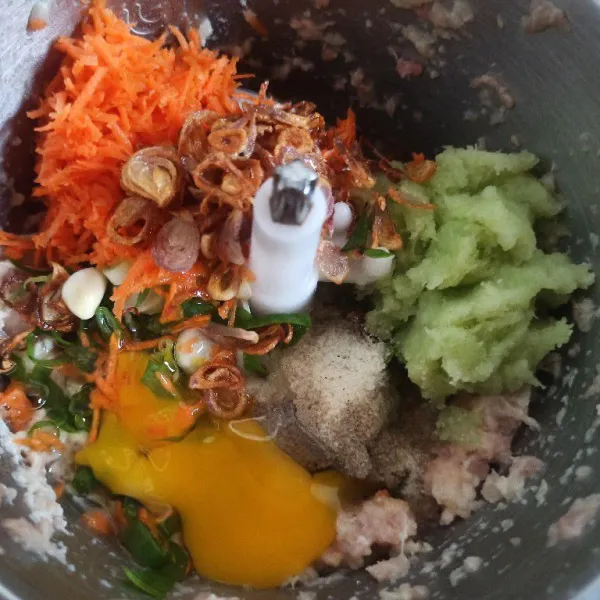 Selanjutnya masukkan telur, wortel, daun bawang, labu siam, garam, gula, kaldu bubuk, lada bubuk, bawang putih dan bawang goreng cooper kembali sampai halus.