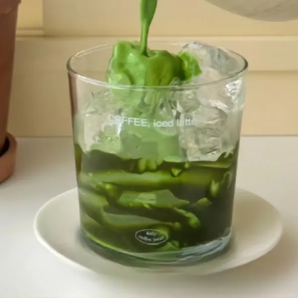 Tuangkan campuran matcha ke dalam gelas, sisakan sedikit untuk dipakai urutan terakhir.