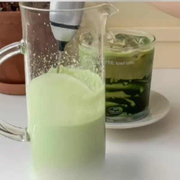Campurkan bubuk matcha dengan susu panas dan aduk rata. Masukkan es batu ke dalam gelas, blender hingga tercampur rata.