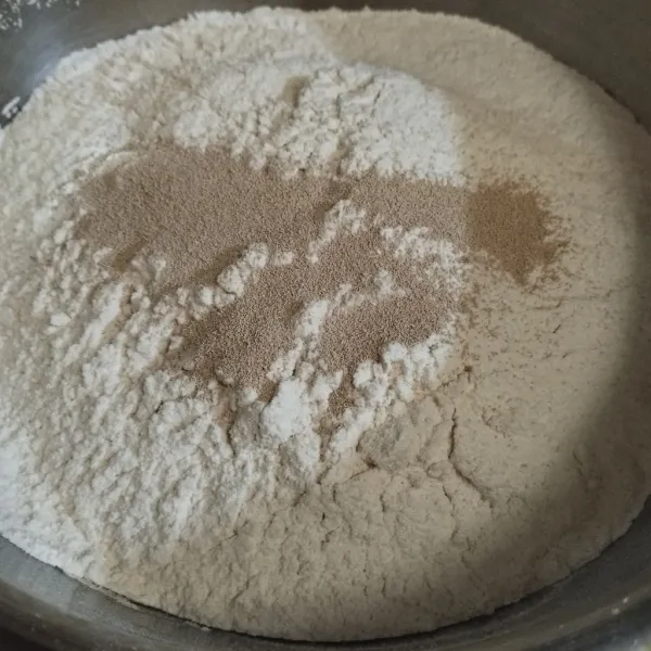 Campur tepung beras, tepung terigu, gula pasir, ragi, dan vanili. Aduk secara merata.