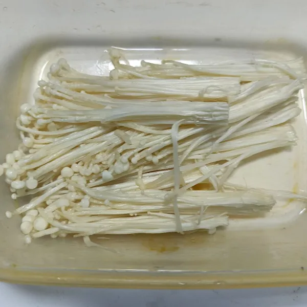 Siapkan jamur enoki. Potong dan buang akarnya kemudian pisah-pisahkan jamur dan cuci bersih.