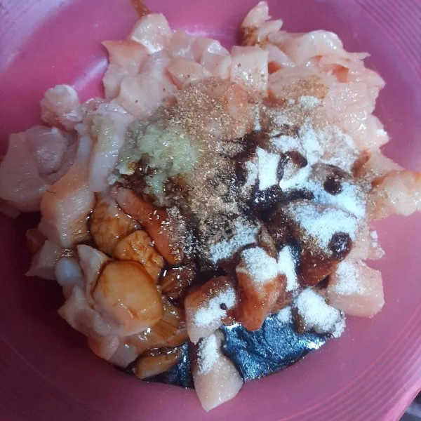Cuci bersih ayam fillet lalu beri perasan jeruk nipis diamkan 10 menit bilas dengan air sekali dan potong-potong dadu ayam, masukan bumbu mari nasi, bawang putih, bubuk ketumbar, garam, dan kecap manis.