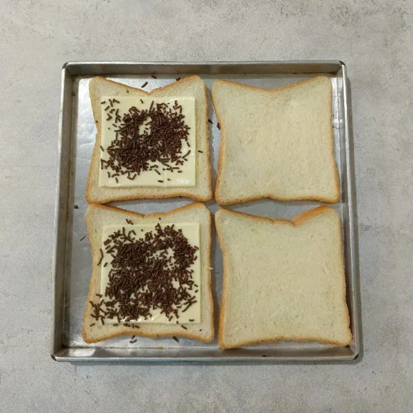 Tambahkan coklat meses dan krimer kental manis putih diatas keju.