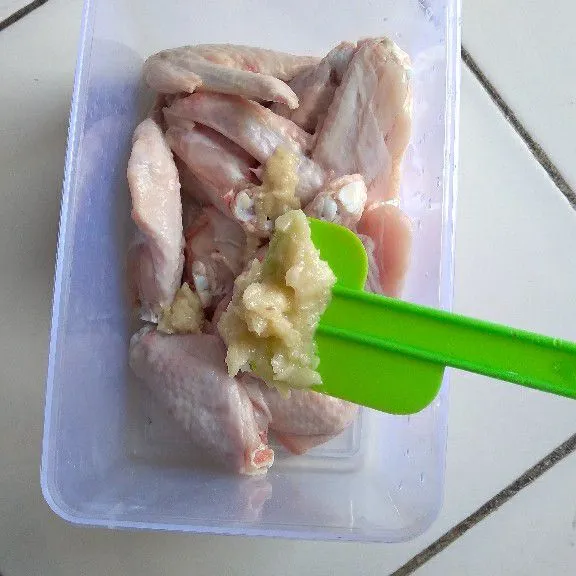 Campurkan ayam dan bawang putih di wadah.