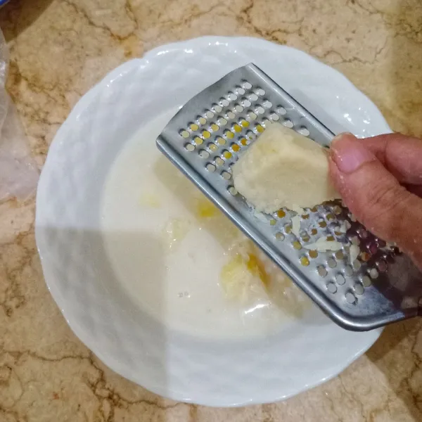 Tuang setup tape singkong ke dalam mangkok, beri parutan keju cheddar. Sajikan.