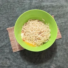 Masukkan mie keriting matang yang sudah dipotong-potong dan kaldu bubuk instan, lalu aduk rata.
