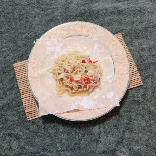 Selanjutnya masukkan 2 sendok adonan mie ke kulit lumpia, kemudian lipat berbentuk persegi.
