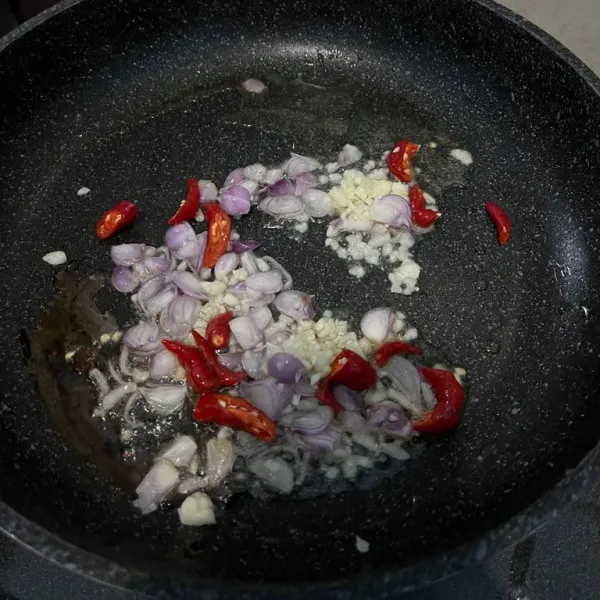 Tumis bawang merah potong serong, bawang bombay, bawang putih cincang, dan sayur sawi bagian batang hingga layu