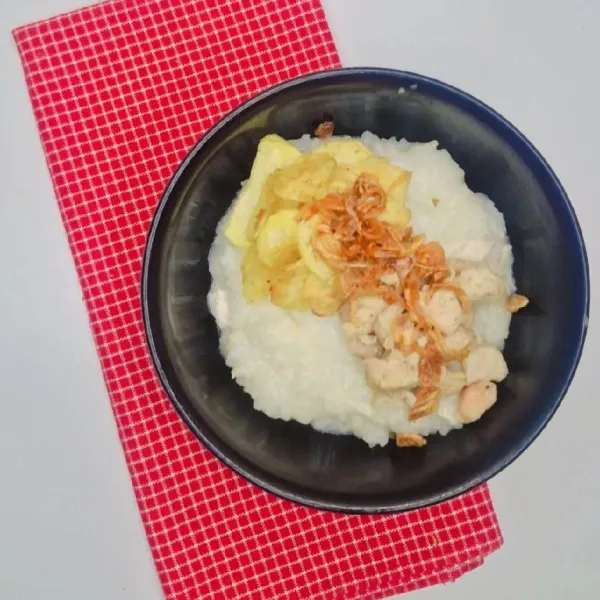 Hidangkan bubur ayam selagi hangat, kemudian tambahkan toping sesuai selera dan taburkan dengan bawang goreng.