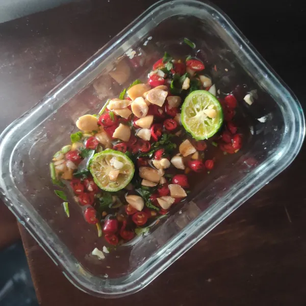 Step ke empat, membuat saus dreassing, perasaan jeruk limau, beri 50 ml air, kemudian masukan cabe, sedikit daun ketumbar, bawang putih, kacang, kecap asin, dan gula palm.