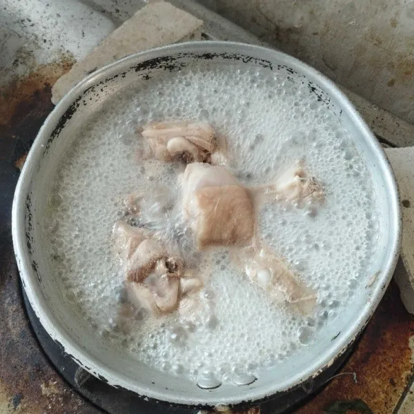 Cuci bersih ayam, kemudian rebus untuk menghilangkan darahnya. Sisihkan.