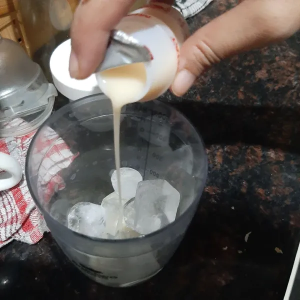 Masukkan susu fermentasi dan es batu ke dalam gelas shaker.