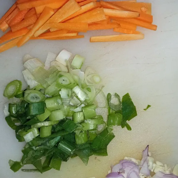 Potong korek wortel dan iris bawang merah, bawang putih, dan bawang prei.