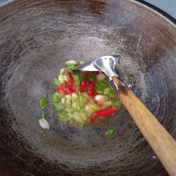 Panaskan minyak goreng, tumis daun bawang dan cabe sampai layu