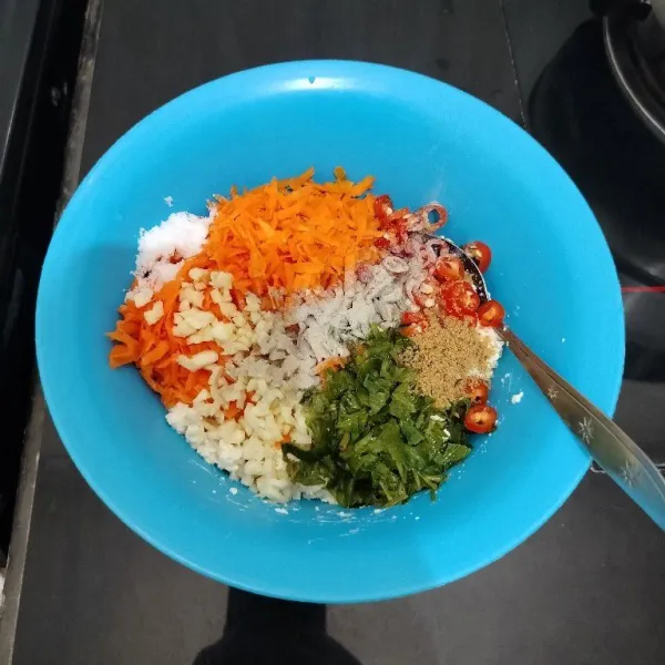 Masukkan wortel, daun seledri, cabai merah, bawang putih, lada bubuk, kaldu bubuk, dan garam. Aduk rata.