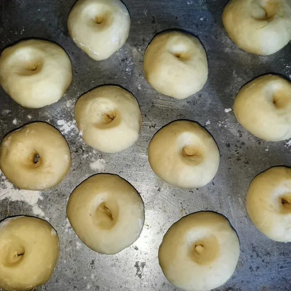 Kemudian bagi adonan jadi 12 buah, bentuk bulat pipih dan lubangi tengahnya. Tutup dan proofing lagi adonan sekitar 20 menit.