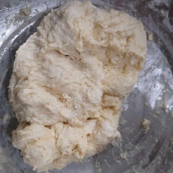 Tuang susu ke dalam tepung, aduk rata lalu tambahkan margarin,aduk kembali hingga kalis