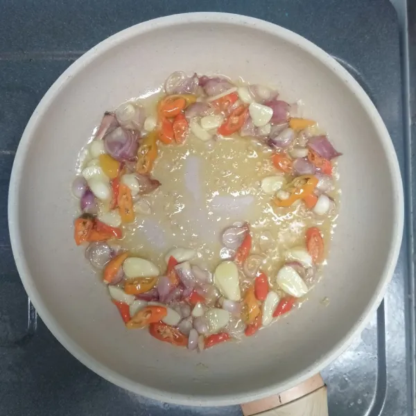 Panaskan minyak. Kemudian tumis bawang merah, bawang putih, dan cabe rawit.