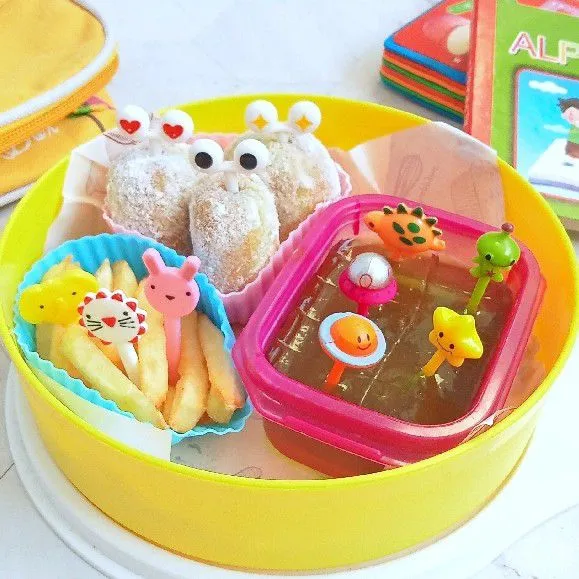 Tata donat didalam wadah bekal dan tambahkan kentang goreng juga jelly melon didalam bekalnya