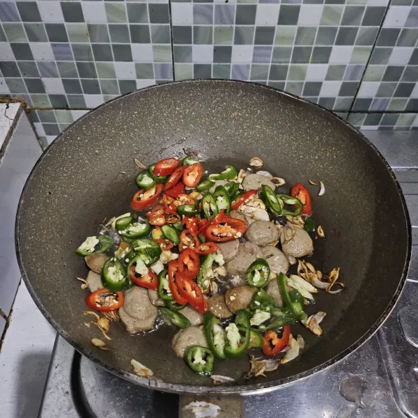 Masukkan cabe merah dan cabe hijau, lalu tumis hingga layu.