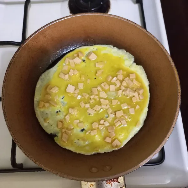 Panaskan margarin pada teflon, tuang setengah adoanan telur ayam