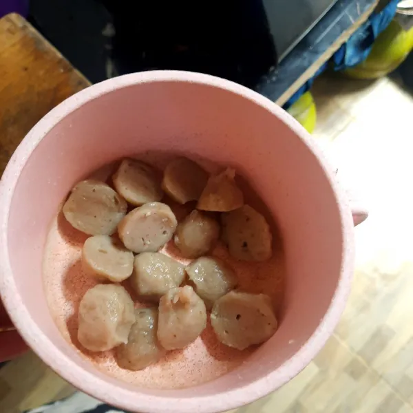 Potong bakso menjadi dua bagian.