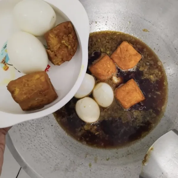 Masukkan telur rebus dan tahu goreng.