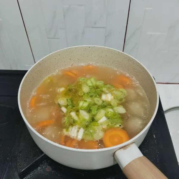 Masukkan garam, kaldu bubuk, daun bawang, dan seledri.